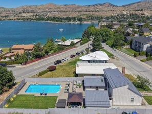 A residential area with a swimming pool, houses, and a road. - Lake Chelan Vacation Rental with private pool and hot tub, sleeps up to 12 (Chelan)