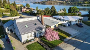A residential area with houses, a parking lot, and a lake with mountains in the background. - Lake Chelan Vacation Rental with private pool and hot tub, sleeps up to 12 (Chelan)