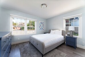 A bedroom with a bed, a dresser, a nightstand, and a window with blinds. - Lake Chelan Vacation Rental with private pool and hot tub, sleeps up to 12 (Chelan)