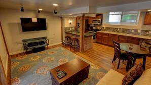 A modern kitchen with a built-in microwave, stove, and bar stools. - Cozy Luxury Remodel, Fantastic Backyard! Walk in 5 minutes to CSU/Old Town (Ft Collins)