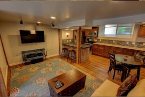 A modern kitchen with a built-in microwave, stove, and bar stools. - Cozy Luxury Remodel, Fantastic Backyard! Walk in 5 minutes to CSU/Old Town (Ft Collins)