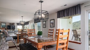 A spacious dining area with a glass-top table, wooden chairs, and a modern pendant light. - Park Pointe C204 - Community Pool/Hot tub (Chelan)