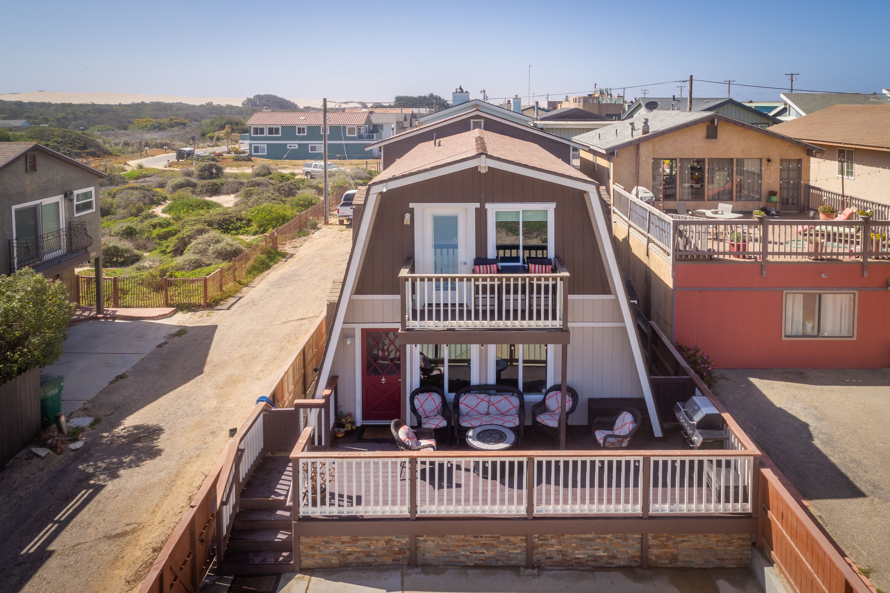 Une maison à deux étages avec un balcon, une allée et une vue sur le quartier environnant.