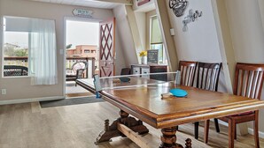 A dining area with a wooden table, chairs, and a view of the outside.