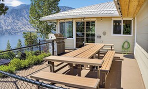 Un chalet au bord du lac, doté d’une terrasse, d’un barbecue extérieur et de tables de pique-nique.