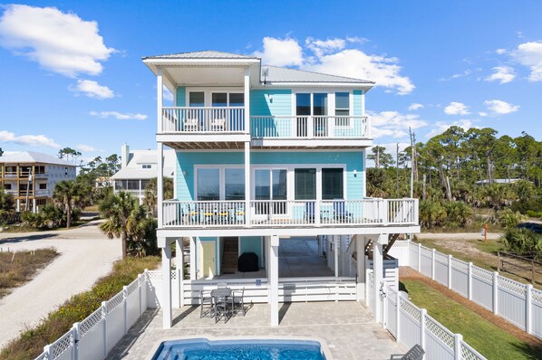 A two-story beachfront property with a swimming pool, balconies, and a view of the beach. - About Time: Beach Views, Private Pool, Pet-Friendly, Dog Run and Sleeps 14 (Port St. Joe)