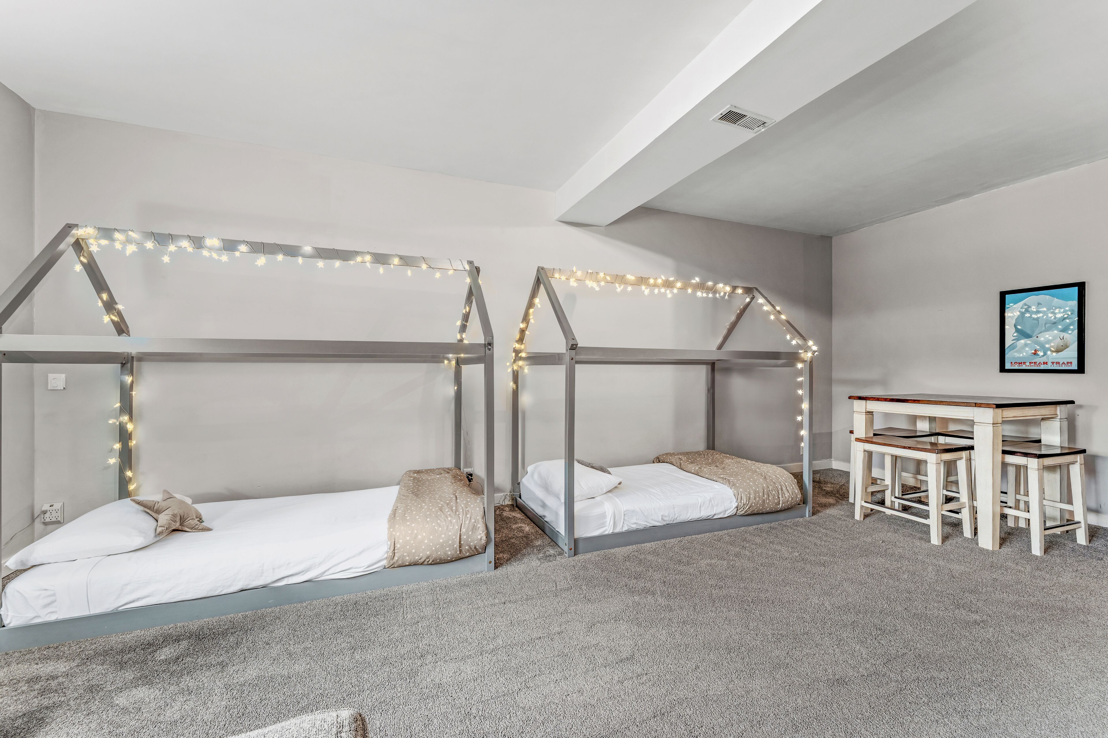 A bedroom with two bunk beds, a desk, and a chair.
