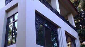 Un edificio de dos pisos con ventanas grandes y un balcón.
