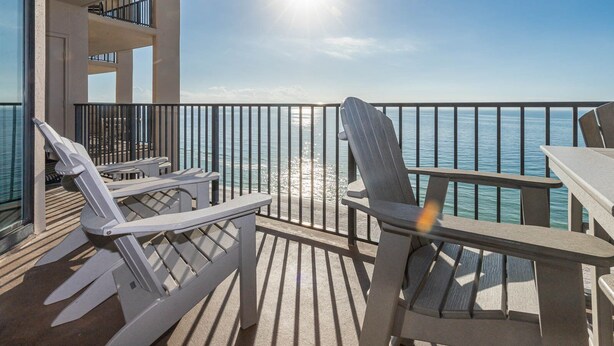 A balcony with a view of the sea, featuring two Adirondack chairs and a table. - Relax. Recharge. Repeat 3 BR Phoenix X 1407 (Orange Beach)