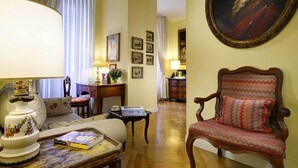 A traditional room with a sofa, a wooden chair, a table with a lamp, and a framed portrait on the wall. - Close to Navona Square, Exclusive cozy Apt AC, WiFi. Perfect base for touring (Roma)