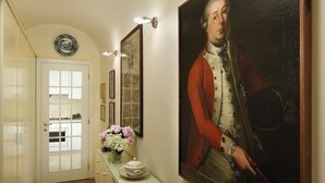 A hallway with a white door, a vase of flowers, and a framed painting. - Close to Navona Square, Exclusive cozy Apt AC, WiFi. Perfect base for touring (Roma)