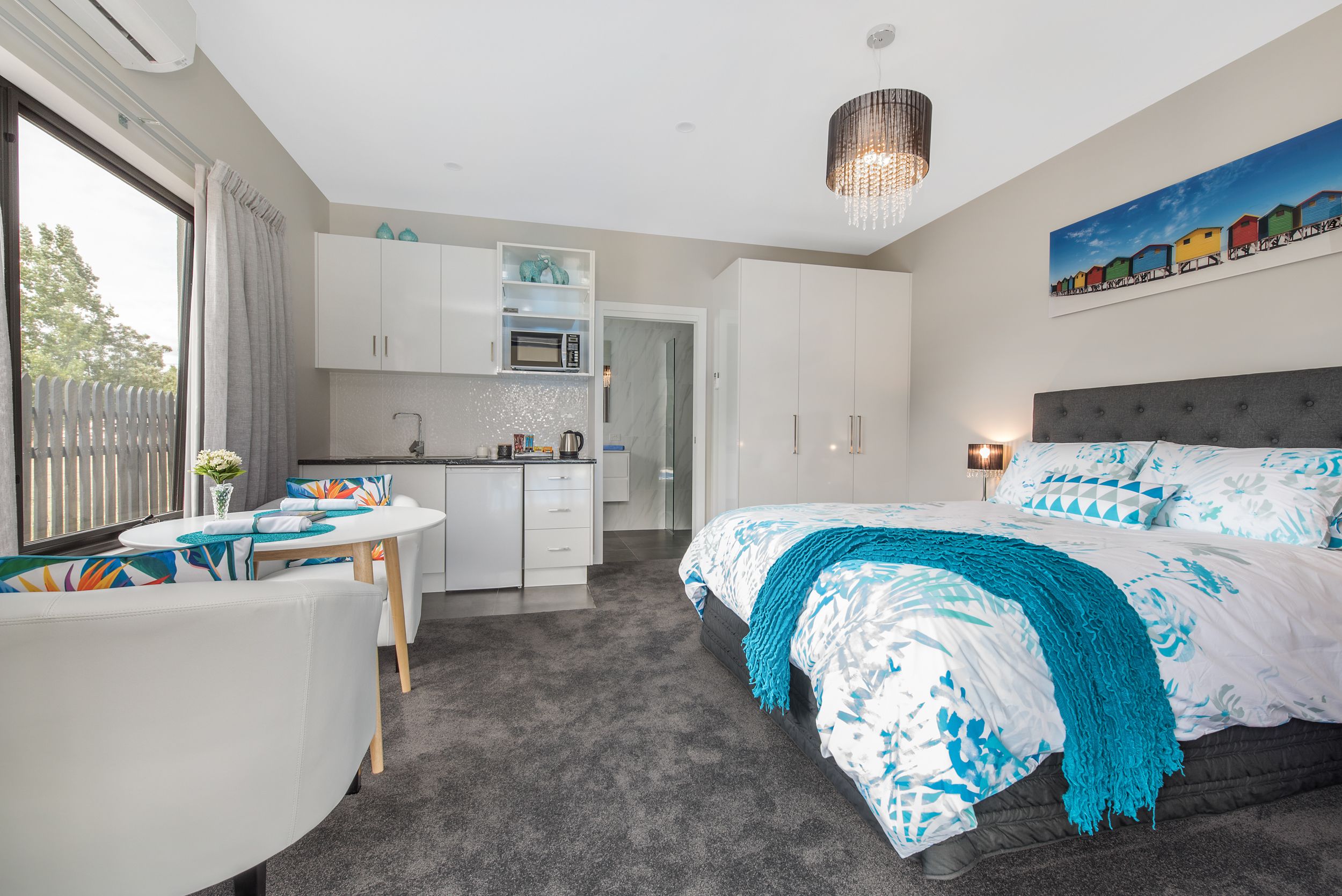 Une chambre moderne dotée d’un grand lit, d’un coin repas et d’une kitchenette.