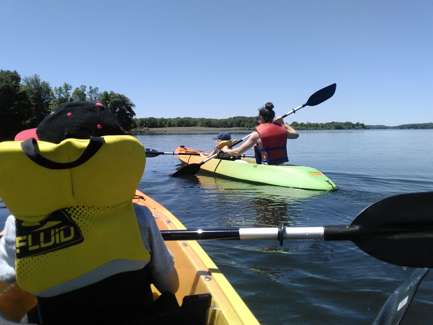 Un kayak sobre un lago tranquilo, con una persona remando.