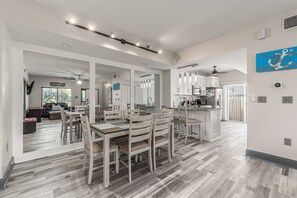 A spacious kitchen with modern appliances, a dining area with wooden furniture, and a large island.
