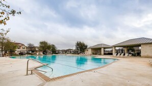 A swimming pool with lounge chairs and a covered area, surrounded by houses and trees. - BMT Grads Stay! Minutes to Lackland + Pool & Theme Parks (San Antonio)