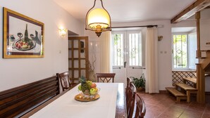 A dining area with a wooden table, chairs, a fruit bowl, and a painting on the wall. - Property with a swimming pool, rare find within walking distance to Old Town (Dubrovnik)