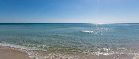 Una playa con agua cristalina y un cielo soleado.