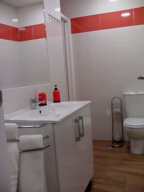 A bathroom with a white sink, red soap dispenser, toilet, and a metal handrail. - COMPLETELY RENOVATED HOUSE WITH FREE WIFI (TOLEDO)