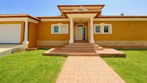 A two-story house with a front porch, a garage, and a well-maintained lawn. - Quiet Villa with wifi and air conditioning Finca Las Ranas (Denia)