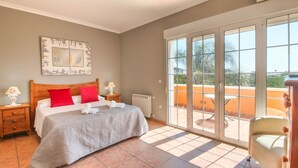 A bedroom with a bed, two nightstands, a radiator, and a large sliding glass door leading to an outdoor area. - Quiet Villa with wifi and air conditioning Finca Las Ranas (Denia)