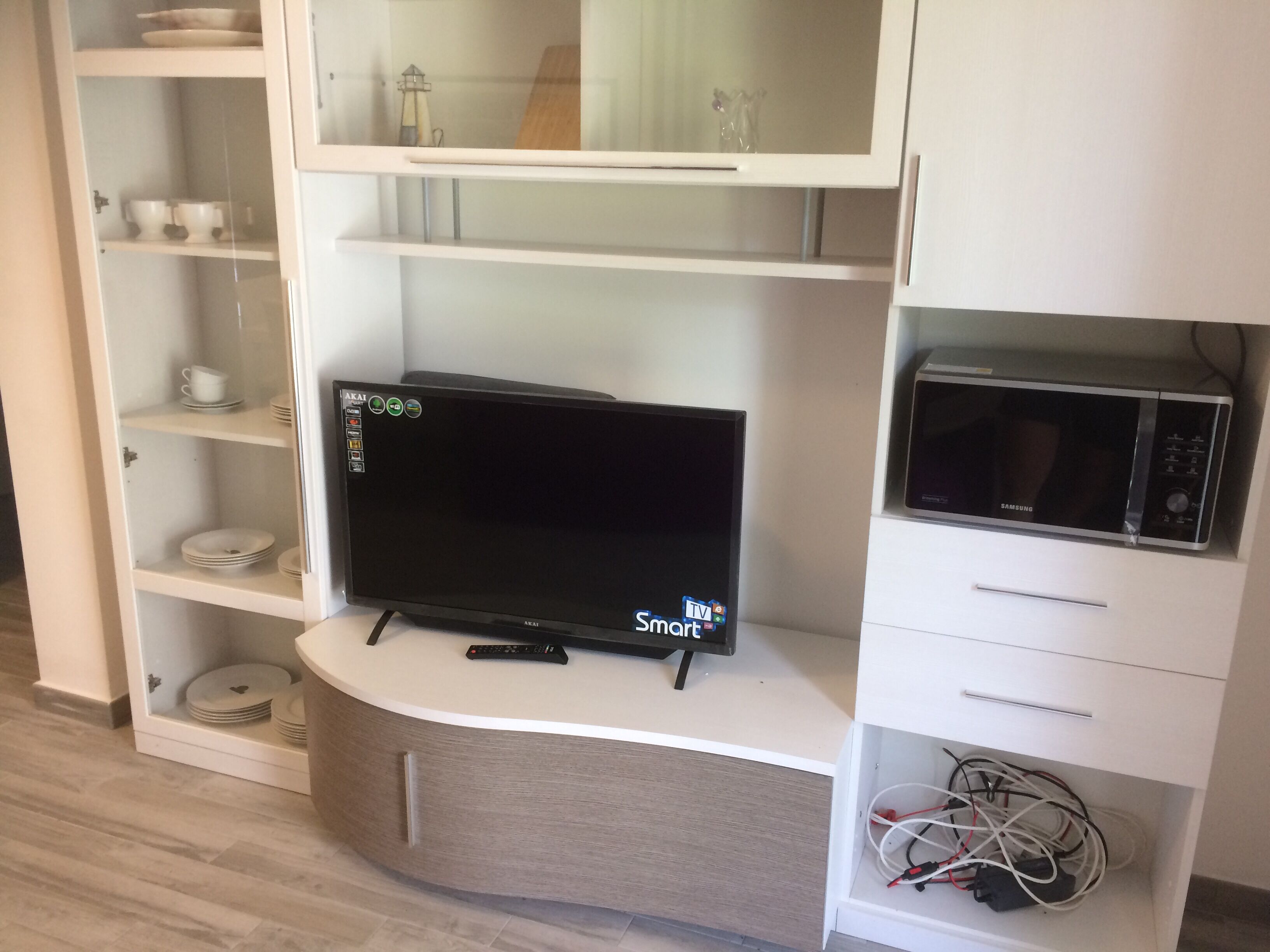 A kitchen with a built-in TV, microwave, and cabinets.