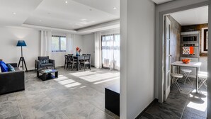 A modern living room with a sofa, coffee table, and dining area. - Falesia Beach B (Albufeira)