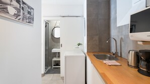 A modern kitchen with a wooden countertop, stainless steel sink, and a built-in oven. - I-Centre of old Lisbon in first floor (Lisboa)