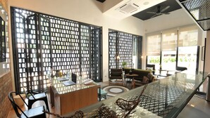 A modern interior with a glass partition, a reception desk, and seating area.