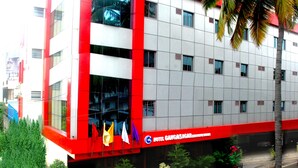 A hotel with a red and white facade, multiple windows, and a sign indicating it is a hotel. - Hotel Gangasagar (Bengaluru)