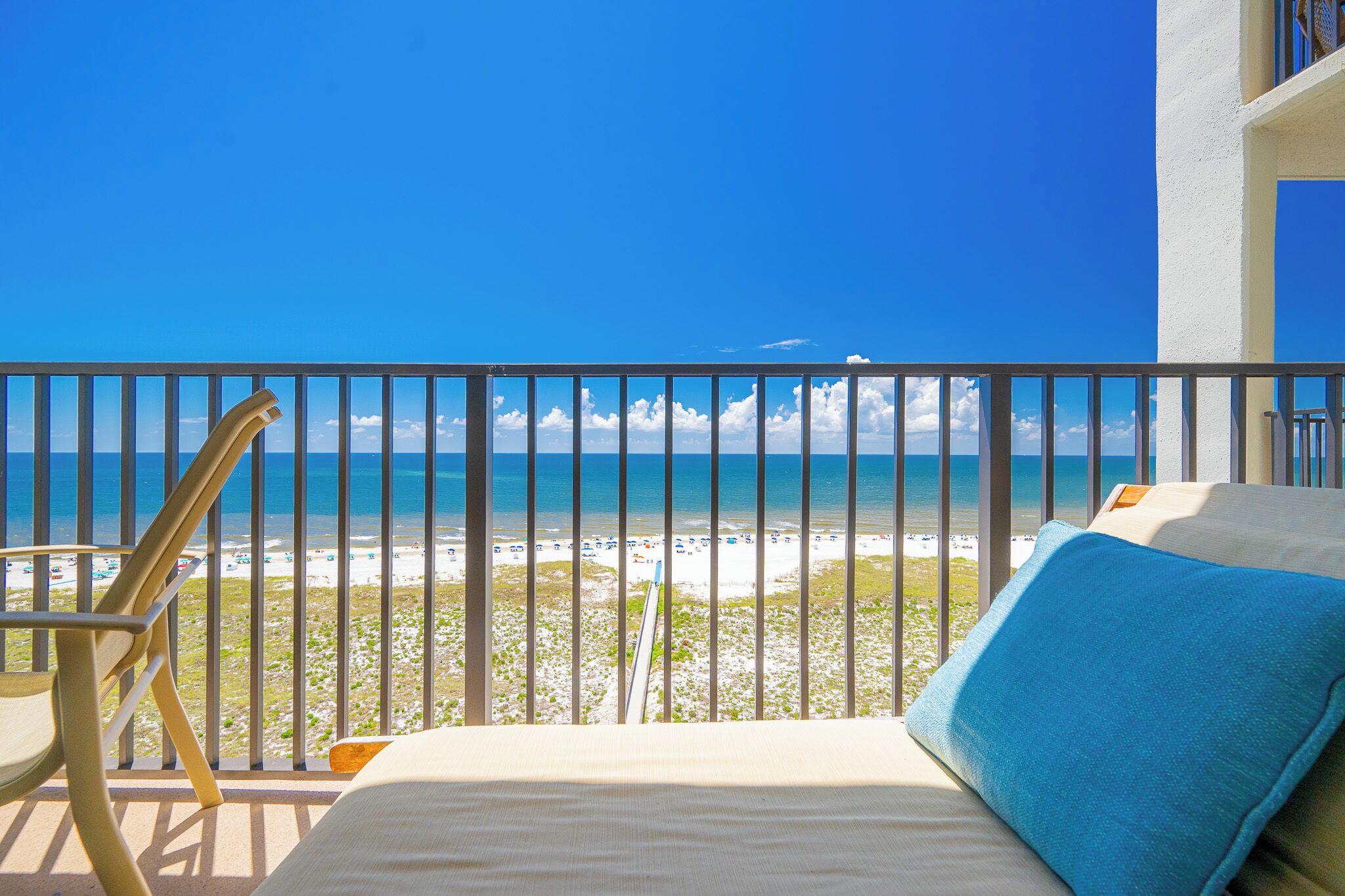 Un balcon avec vue sur une plage et l’océan.
