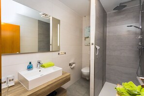 Een douche, een haardroger, zeep, toiletpapier