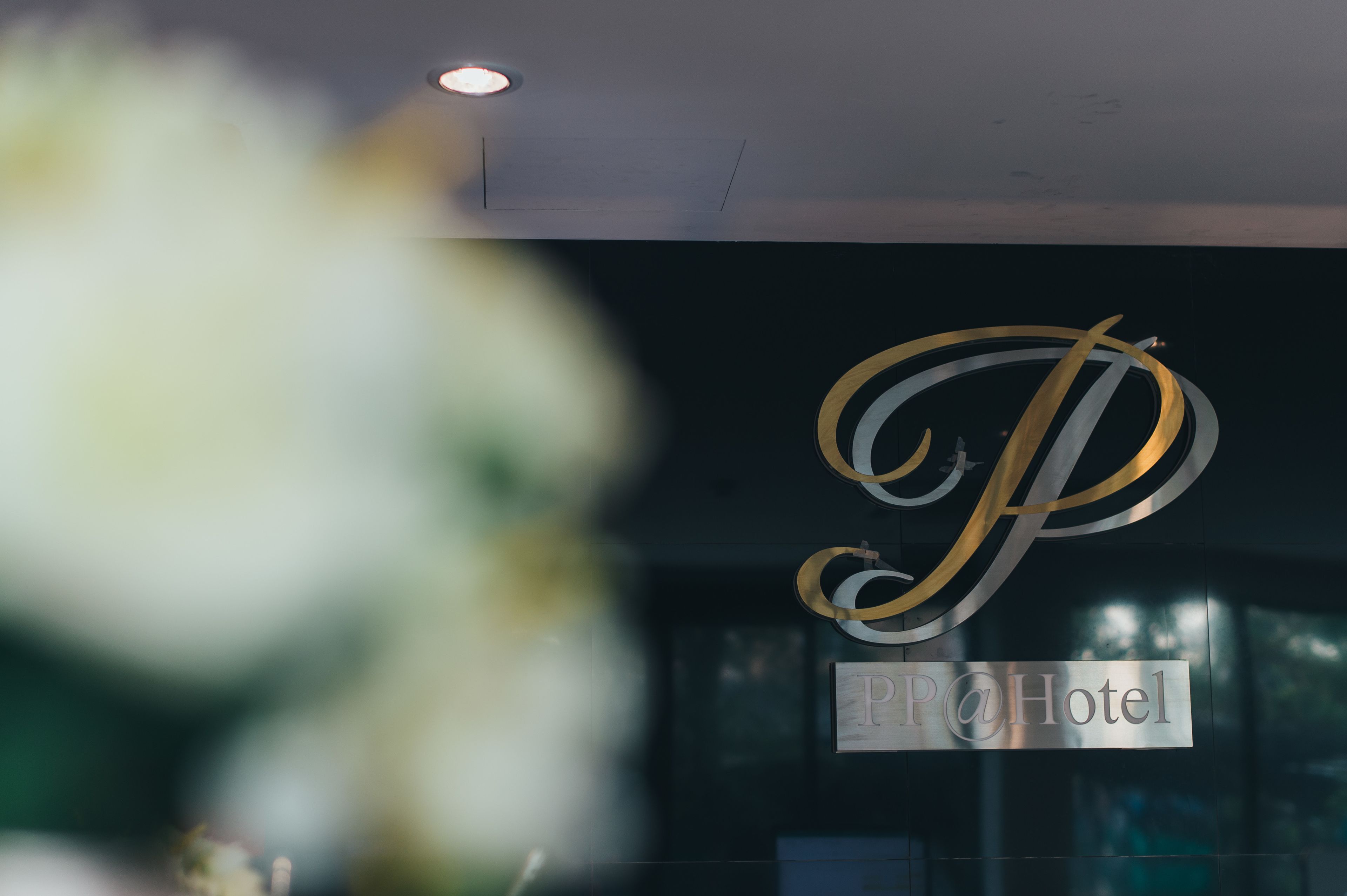 Un letrero de hotel con un gran logotipo en forma de 'P' y el texto 'P@Hotel' sobre un fondo oscuro.