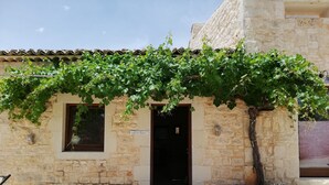A stone building with a tiled roof, a door, and a sign that reads "Reception." - Le Chiuse di Guadagna (Scicli)