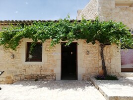 Un edificio in pietra con tetto in tegole, una porta e un cartello con su scritto 'Reception'.