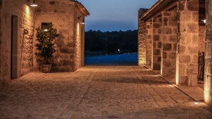 A stone corridor with a potted plant and a view of a distant landscape. - Le Chiuse di Guadagna (Scicli)