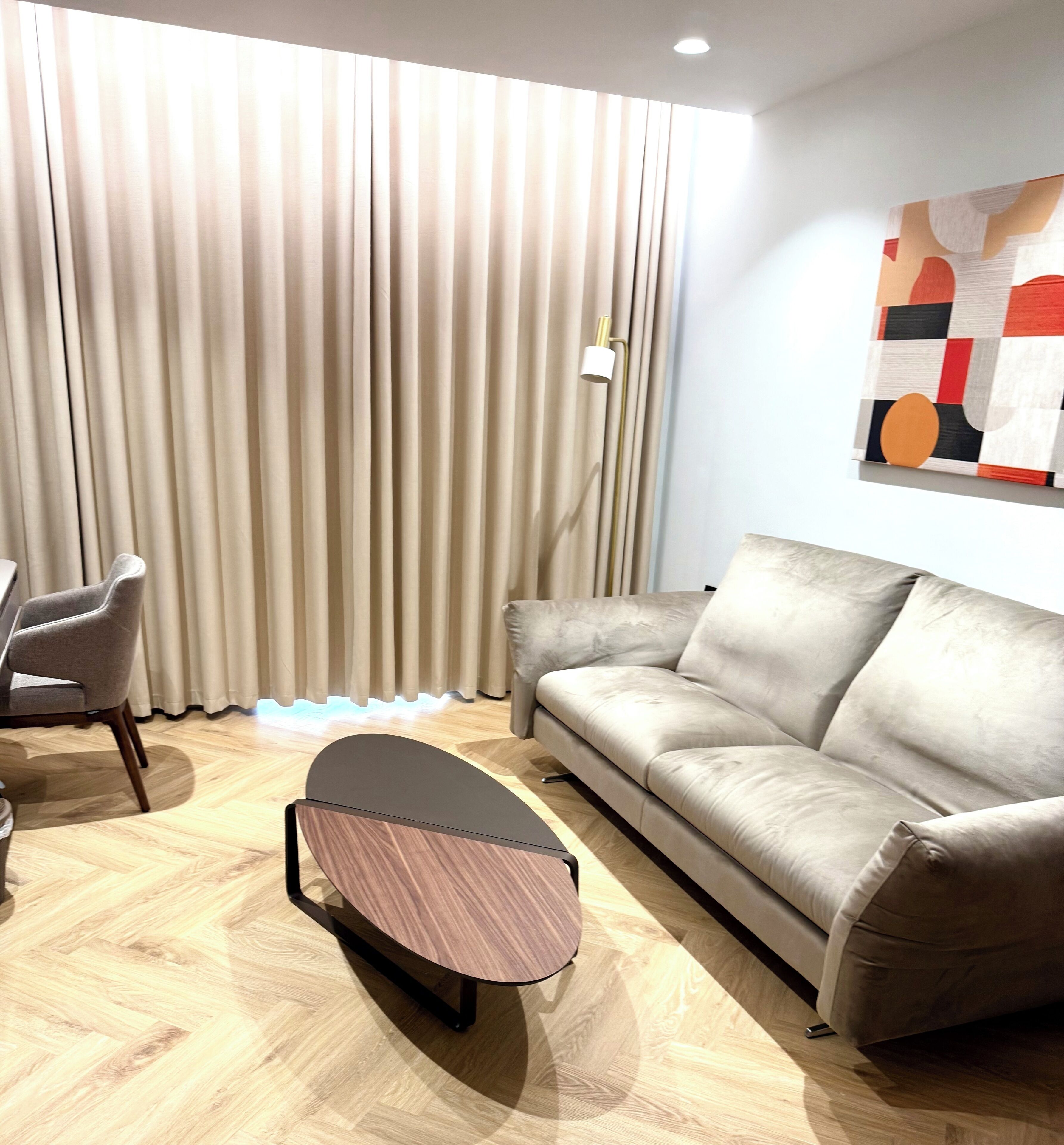 Una sala moderna con un sofá, un sillón y una mesa de centro.