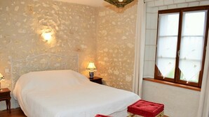A bedroom with a bed, a nightstand, a lamp, and a window with curtains. - 19th Century Wine House in Loire Valley, near castles (Cangey)