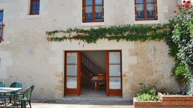A building with a stone facade, a covered outdoor seating area, and a staircase leading to an upper floor. - 19th Century Wine House in Loire Valley, near castles (Cangey)
