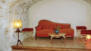 A cozy room with a red sofa, a small round table, and a lamp. - 19th Century Wine House in Loire Valley, near castles (Cangey)