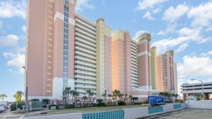 A multi-story hotel with a modern design, featuring a prominent central tower and a series of smaller buildings.