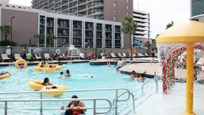 A swimming pool with multiple lanes, lounge chairs, and a water fountain.