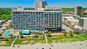 A modern hotel with a pool, beachside lounge, and a view of the surrounding cityscape. - 3Bd Condo in Beachside Resort w/ Amenities Galore! (Myrtle Beach)