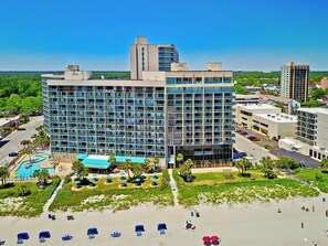 Ett modernt hotell med pool, en lounge vid stranden och utsikt över den omgivande staden.