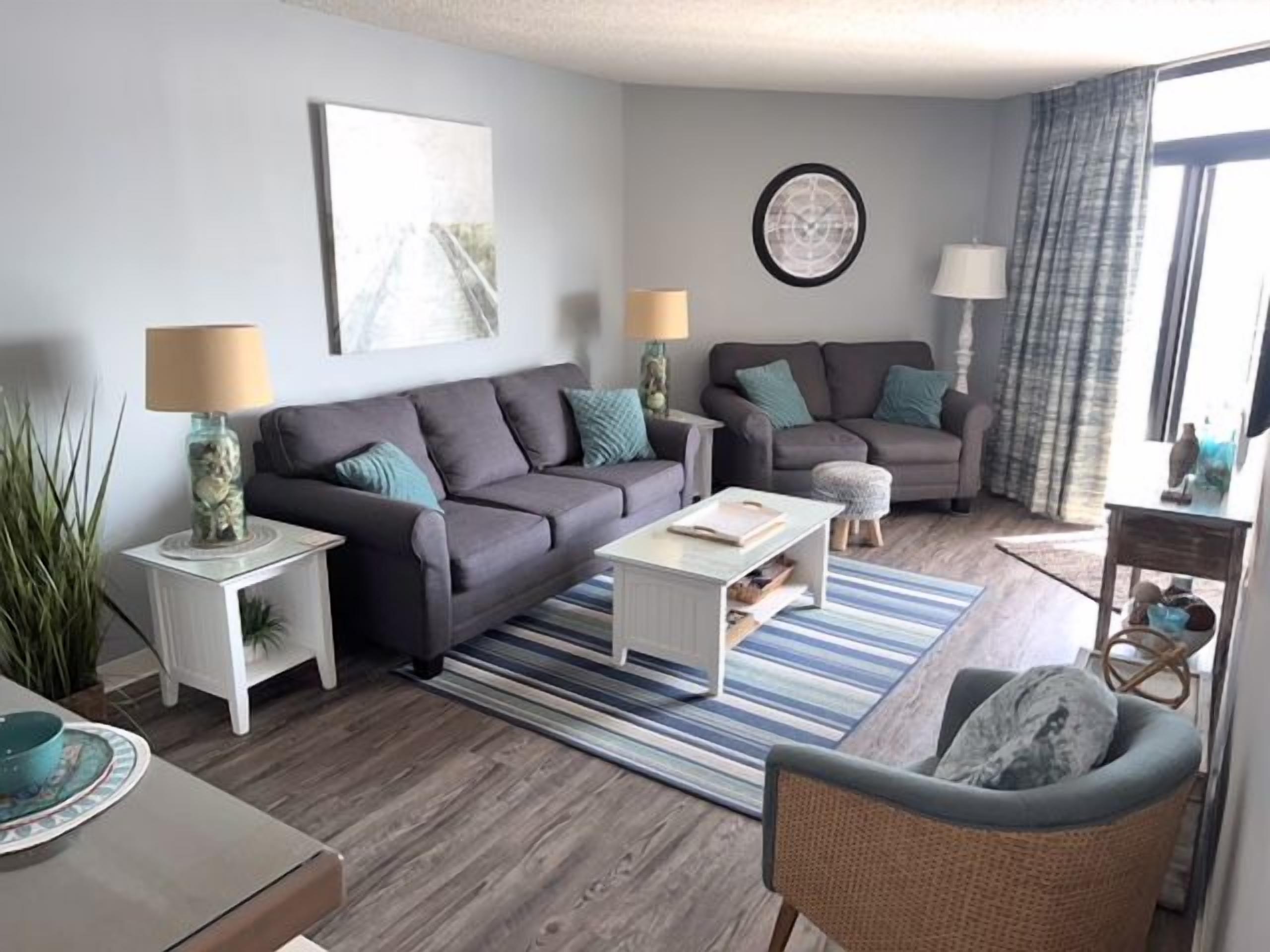 Ein modernes Wohnzimmer mit zwei Sofas, einem Couchtisch und einem Beistelltisch mit Lampe.
