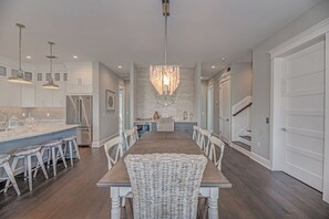 Enjoy meals in the spacious kitchen and dining area, featuring a central island, sink, and stainless steel refrigerator.