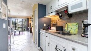A kitchen with white cabinets, a granite countertop, a stove, and a sink.