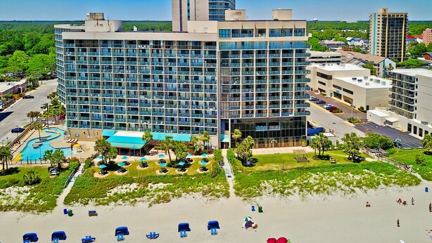 A modern hotel with a pool, beachside lounge, and a view of the surrounding cityscape. - Direct Oceanfront Studio On The Golden Mile (Myrtle Beach)