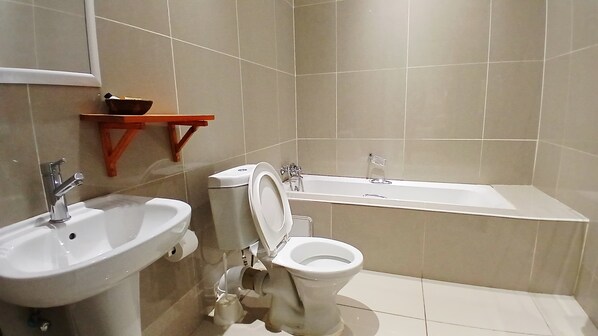 Un baño con lavamanos, inodoro y bañera.
