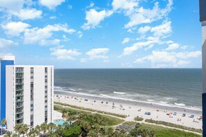 Uitzicht op een strand met een hotel, zandstrand en oceaan.