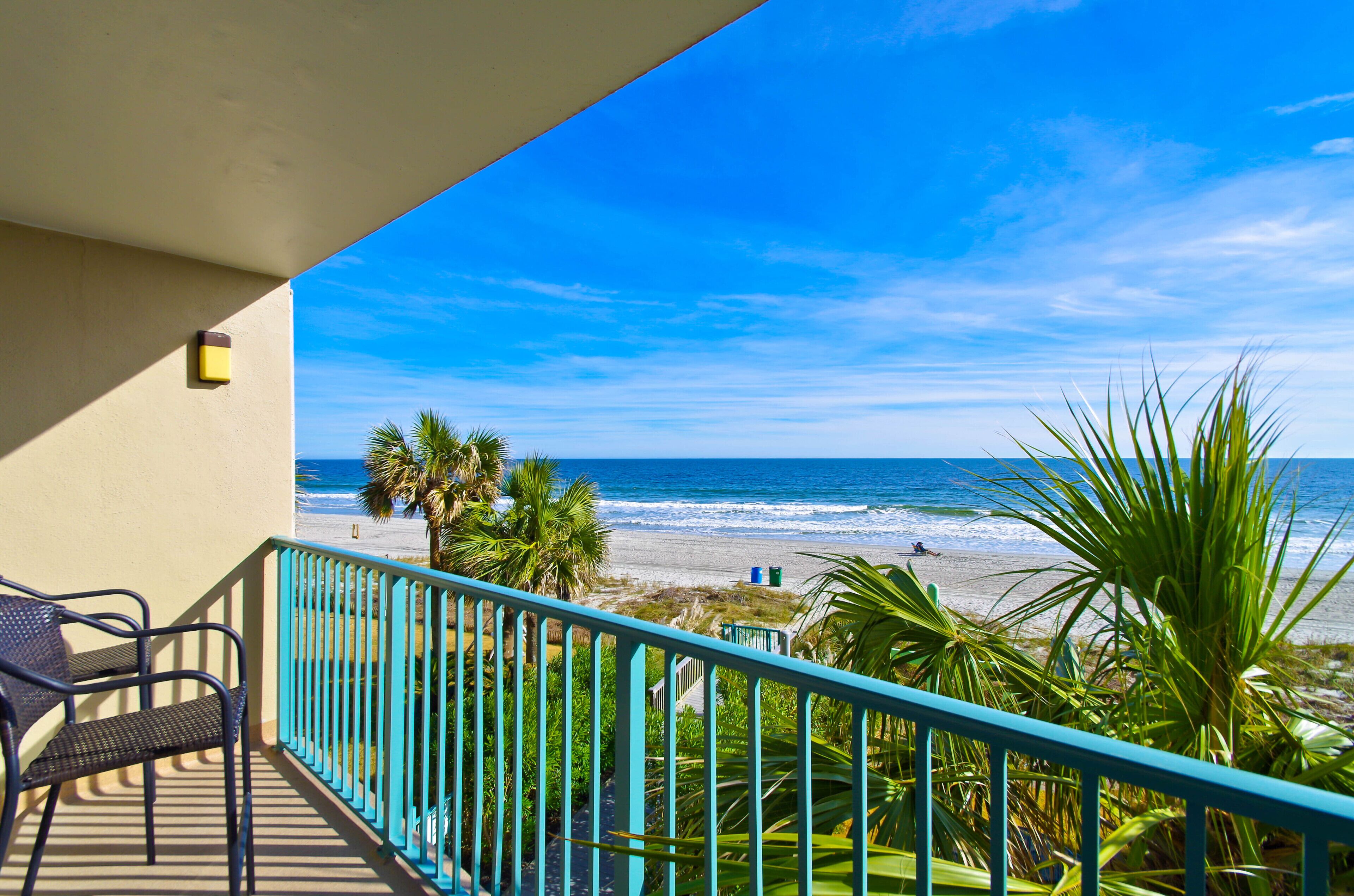 Ein Balkon mit Blick auf den Strand und das Meer.